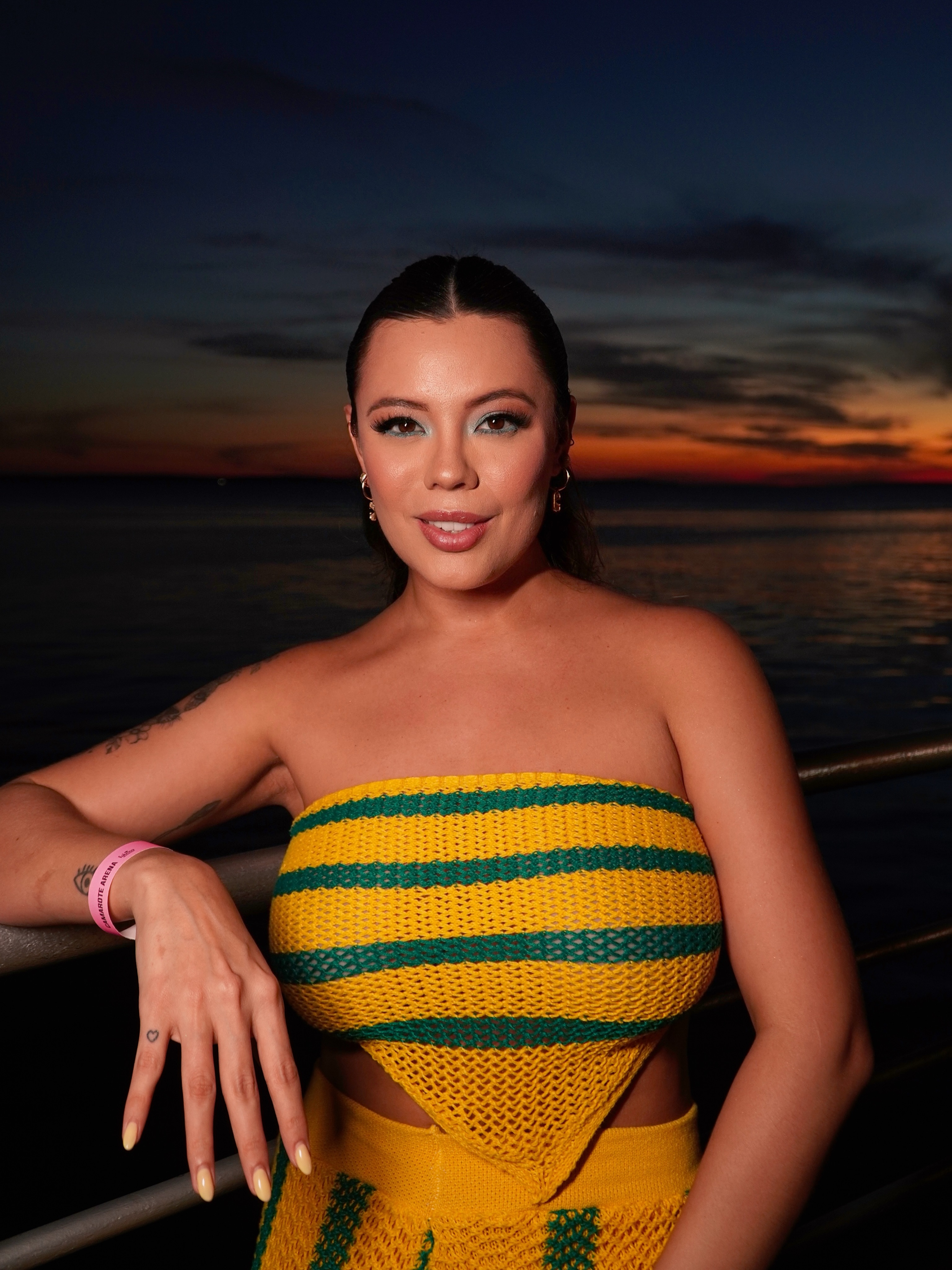Bruna à beira do rio, no pôr do sol